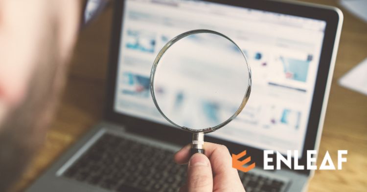 Person examining a laptop screen through a magnifying glass, representing an SEO review