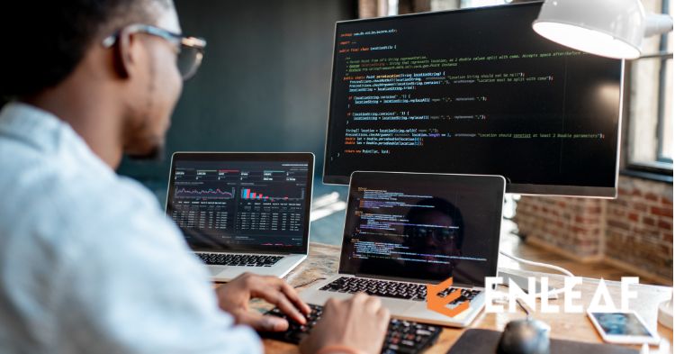 Developer coding on multiple screens, one showing an analytics dashboard